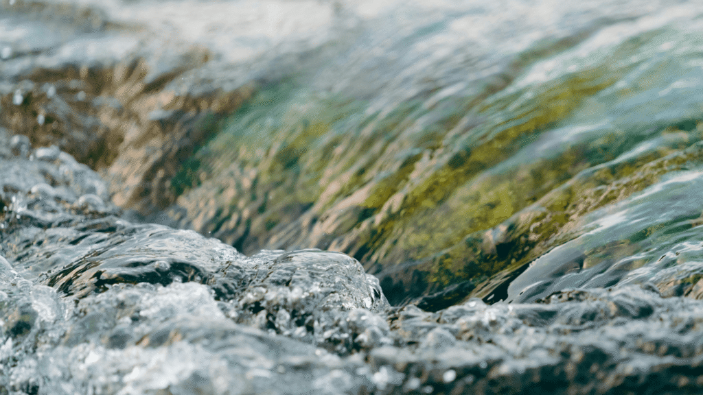 Água corrente suave sobre pedras em ambiente natural